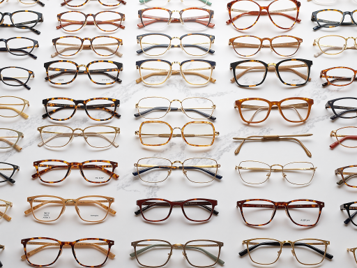 Collection of optical accessories including blue light blocking glasses and reading glasses, various frame styles on clean background